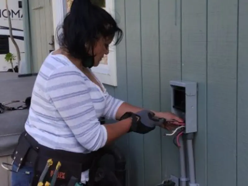 Licensed electrician wiring an exterior subpanel in Bigfork